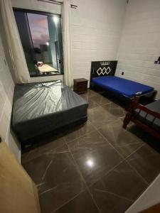 Zimmer mit einem Bett und einem Fenster in der Unterkunft Espaço Mattigor in Caçapava