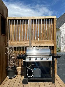 una parrilla en una terraza con una valla de madera en Green Lodge, en Perros-Guirec