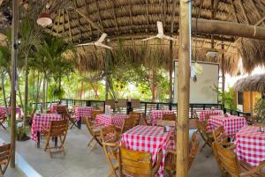 un restaurante con mesas y sillas rojas y blancas en Bikini Hotel & Pool, en Palomino