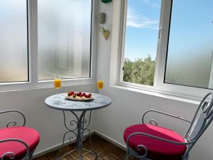 a table with two chairs and two glasses of orange juice at Hvar Sunny hill in Hvar