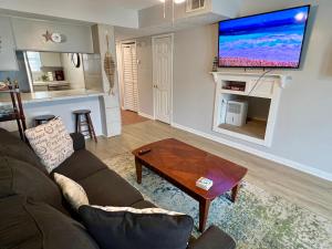 a living room with a couch and a tv on a wall at Commodore's Landing 203 - Gone Sailing, Free Activities Included! in Fort Walton Beach
