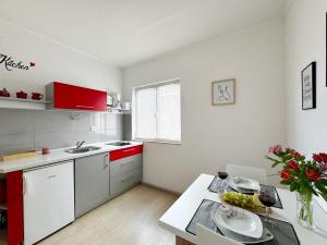 a kitchen with red cabinets and a table with plates on it at Hvar Sunny hill in Hvar