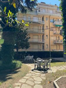 a table and chairs in front of a building at Residence La Scogliera in Alassio