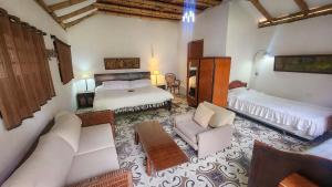 a bedroom with two beds and a living room with a couch at Casa Carmelita Hotel Boutique Pitalito in Pitalito