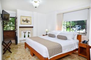 a bedroom with a large bed and a fireplace at La Campana Hotel Boutique in Medellín