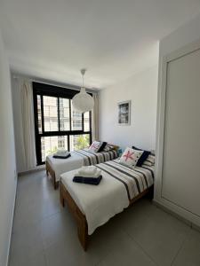 a bedroom with two beds and a large window at Mamba Beach II in Calpe