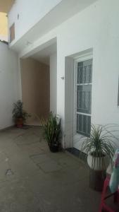 een wit gebouw met planten voor een raam bij Casa BH Arcondicionado todos quartos e garagem in Belo Horizonte
