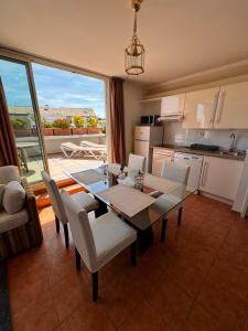 a kitchen and dining room with a table and chairs at Penthouse avec Jacuzzi - Terrasse - Parking - Piscine in Antibes