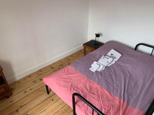 een slaapkamer met een bed met een roze deken bij Ibis Rouge in Villars-les-Dombes