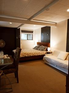 a bedroom with two beds and a table and a chair at Singing Nature in Brisbane