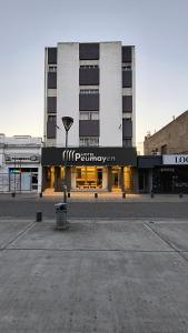 a large building with a sign in front of it at Hotel Peumayen in Viedma