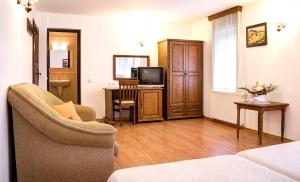 un soggiorno con un divano e una televisione di Strannopriemnitsa Guest House a Bozhentsi