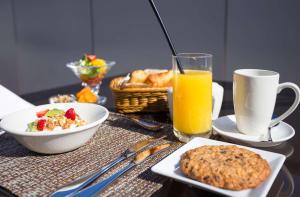 a table with breakfast foods and a glass of orange juice at Comfort Inn By the Bay in San Francisco