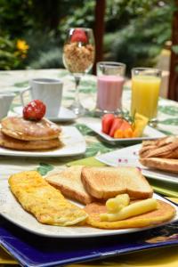 a table with plates of breakfast foods on it at La Campana Hotel Boutique in Medellín