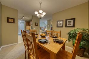 a dining room with a wooden table and chairs at The Peaks 3 Bedroom Mountain View Condo in Radium Hot Springs