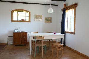a white table and chairs in a room with a window at Hof Welzin - Stellmacherei in Passow