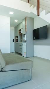 a living room with a couch and a tv at SUNNY HALL Porto de galinhas in Porto De Galinhas