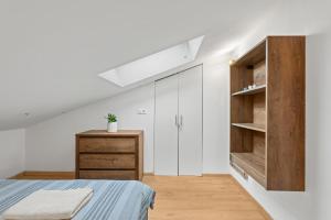 Schlafzimmer mit weißen Wänden, einem Bett und einem Holzschrank in der Unterkunft Alba Sanja in Funtana
