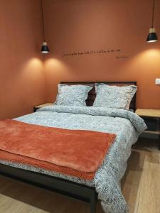 a bedroom with a bed with a quote on the wall at La Cachette in Châteauneuf-de-Galaure