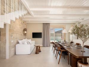 a dining room and living room with a table and a couch at Pietra Di Sabbia Villas in Palaiochora