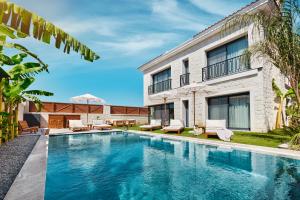 a swimming pool in front of a house at Meruno Alaçatı in Çeşme