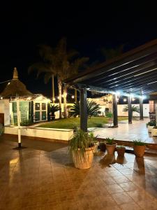 un patio con piante in vaso e luci notturne di Villa con piscina esclusiva a Mazara del Vallo