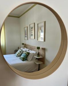 a bedroom with a bed with a large round mirror at Casa Margherita (Alba) in Alba