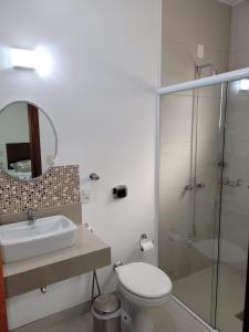 y baño con aseo, lavabo y ducha. en Hotel Vila Germânica, en Blumenau