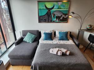 a bedroom with a bed and a couch with a stuffed animal on it at Luxury Downtown Vancouver Suite in Vancouver