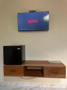 a flat screen tv sitting on top of a wooden entertainment center at Baruch Tropical Ranch in Los Santos