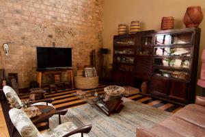 a living room with a tv and a brick wall at Cas'Amazonia Brasil in Belém