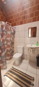 a bathroom with a toilet and a sink at Suíte pé na areia in Icapuí