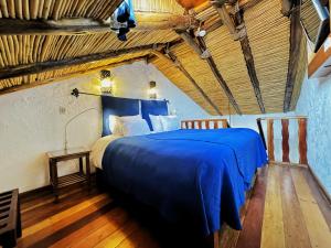 1 dormitorio con 1 cama azul y suelo de madera en ARQUEOLOGO EXCLUSIVE SELECTION - Casa Peralta, en Cusco