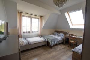 een slaapkamer met 2 bedden, een bureau en 2 ramen bij Willa Hydrograf in Ustka