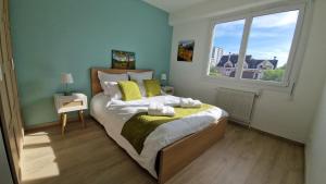 安锡Lac Plage et Ville 95 m2 a 100m du lac, 3 chambres, parking的一间卧室，有一张带黄色枕头的床和一扇窗户