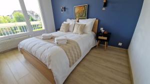 安锡Lac Plage et Ville 95 m2 a 100m du lac, 3 chambres, parking的蓝色卧室配有一张大床和毛巾