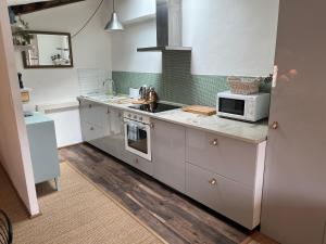 a kitchen with white cabinets and a microwave at Lovely appartement with views in secret Provence in Joucas