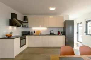 eine Küche mit weißen Schränken und einem Edelstahlkühlschrank in der Unterkunft Villa Pava in Zadar