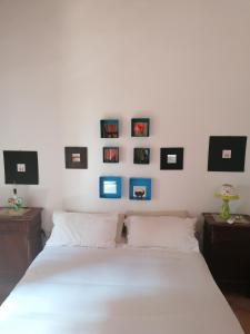 um quarto com uma cama branca com fotografias na parede em B&B CasaCorì em Orosei