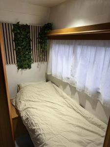 Bett in einem Zimmer mit Fenster und Bettgitter in der Unterkunft Camping Van in Keflavík
