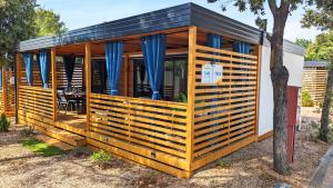 a wooden house with a black roof at Mobile Homes Jaki - 2 Bathrooms, Large Terrace in Biograd na Moru