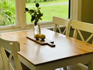 a table with a vase with flowers and lemons on it at Bush Retreat Farm Stay 2 BR Guest Suite in Gelliondale