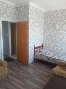 een slaapkamer met een bed en een muur met behang bij Sevan Writers House in Sevan
