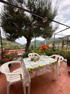 une table et des chaises sur une terrasse avec un arbre dans l'établissement SANREMO Mare e Relax - Affittasi Casa Illiade con parcheggio libero, à Sanremo