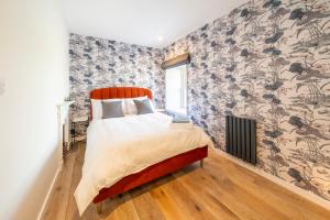 a bedroom with a bed with a floral wallpaper at Boutique Townhouse in Westport