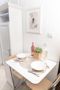 una mesa de comedor blanca con dos platos. en Bakáts Square Luxury Apartment en Budapest