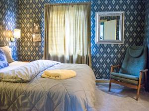 sypialnia z łóżkiem, krzesłem i lustrem w obiekcie Valberg Gjestegård w mieście Valberg