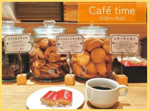 大阪的住宿－Henn na Hotel Osaka Shinsaibashi，桌子,上面放着一罐糕点和一杯咖啡