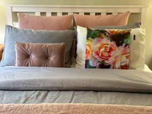 a bed with a bunch of pillows on it at Bush Retreat Farm Stay 1BR Guest Suite in Alberton West