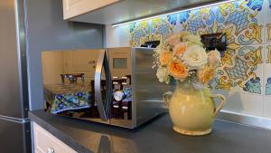 a vase filled with flowers sitting next to a microwave at Stone house in Larciano